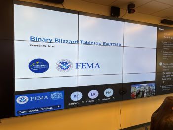 A video board with a slate that says "Binary Blizzard Tabletop Exercise"