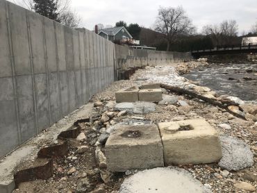 A cement wall along a river in Middlebury